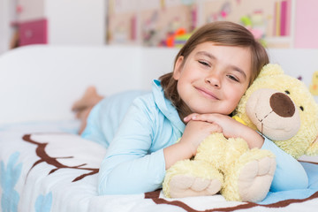 Obraz na płótnie Canvas Cheerful little cute adorable baby girl playing with yellow teddy bear in her children room. Childhood, leisure kid time, happiness concept