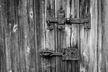 A detailed close up of a shed latch in a grainy black and white image