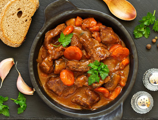 Beef stew in Burgundy. With carrots, onions, peas and champignons in wine. View from above.