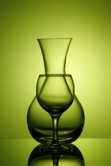 Pitcher and wine glass on green background