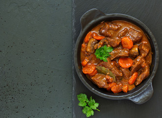 Beef stew in Burgundy. With carrots, onions, peas and champignons in wine. View from above.
