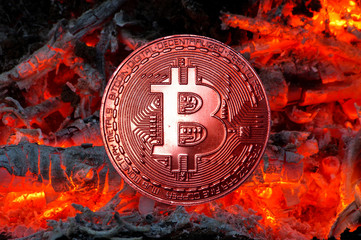 Burnt bitcoin over fire ashes