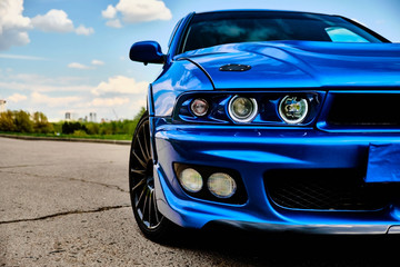 Aggressive sport car in blue against the background of nature - obrazy, fototapety, plakaty