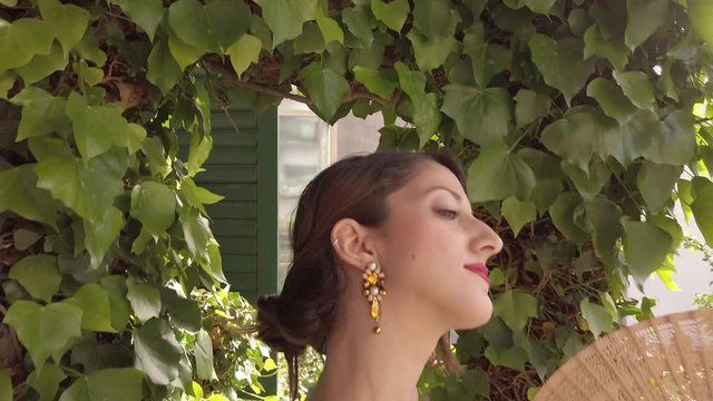 Giovane bella ragazza con maglietta azzurra sorride allegramente nel giardino di casa con il dondolo e gli alberi verdi. Refrigerio per l'Estate.