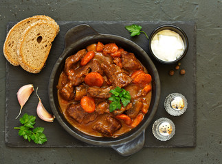 Beef stew in Burgundy. With carrots, onions, peas and champignons in wine. View from above.