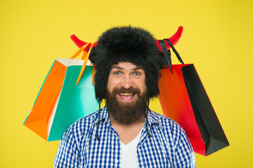 Wild about shopping. Full packages of items. Man strict face wear hat of bull with horns. Hipster...