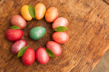 Easter eggs on a wooden background. Happy easter. Bright multicolored shiny easter eggs. Copyspace. Multicolored eggs are lying in circle. Place for text