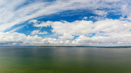 Aerial view of cloudy blue sky over green lake