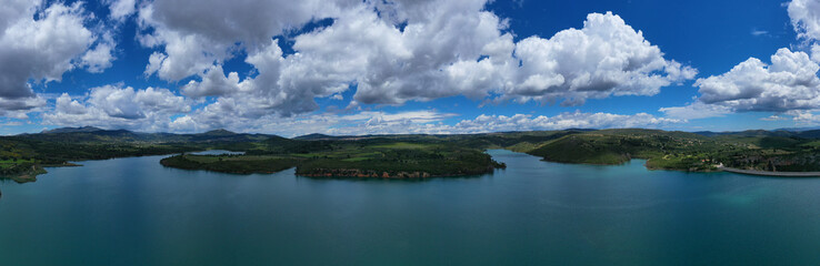 Aerial drone panoramic view of famous dam and lake of Marathon with beautiful clouds, North Attica, Greece