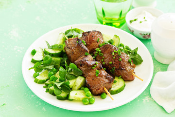 Beef kebab with cucumber and green pea salad. Healthy food.