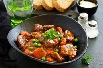 Beef stew in Burgundy. With carrots, onions, peas and champignons in wine. View from above.