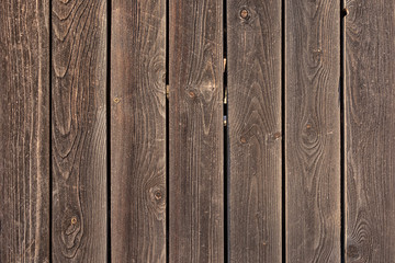 The fence is made of flat wooden planks. Empty background with texture of brown boards. Photo for...