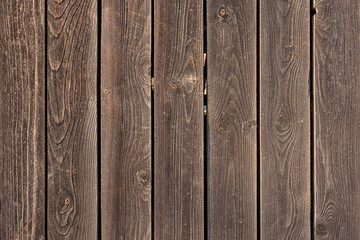 The fence is made of flat wooden planks. Empty background with texture of brown boards. Photo for the layout.