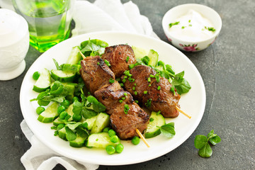 Beef kebab with cucumber and green pea salad. Healthy food.