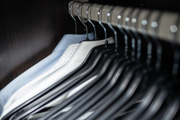 Neat blouse in a mens wardrobe / closet with clothes hangers