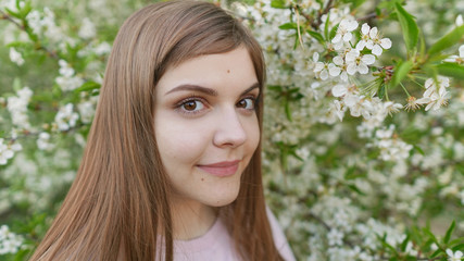 Young beautiful woman smells blooming sakura. Spring woman in cherry flower bloom. Happy mothers day or happy woman day. Outdoor lifestyle. Freedom concept