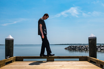 Broomes Island, Maryland USA A young man does exercises on a dock on the Patuxent river.