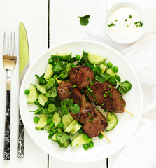 Beef kebab with cucumber and green pea salad. Healthy food.