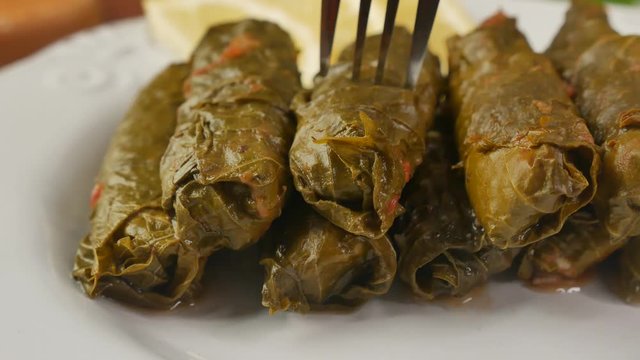 Stuffed Dolma roll impaled on fork, close up
