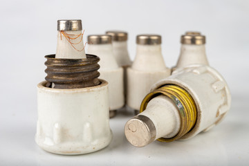 Old ceramic electric fuse. Blown and badly repaired security for energy.