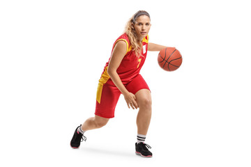 Female basketball player leading a ball