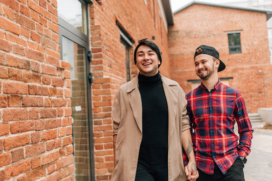 Happy Gay Couple Walking Down The Street Holding Hands. Concepts Of Same-sex Marriage In The World