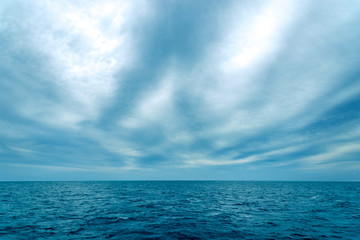 Fototapeta na wymiar minimalistic seascape, blue sea and sky with white clouds on the whole frame