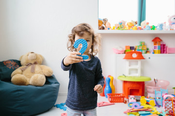 Little girl child playing with numbers puzzle