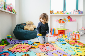 Little girl child playing with numbers puzzle