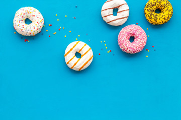 Modern design with bright donuts on blue background top view mock up