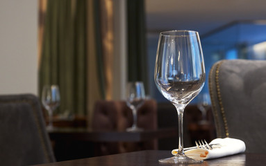 empty wine glass on a table in a restaurant. background is out of focus. interior in a restaurant.
