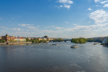 Fototapeta na wymiar Outdoor sunny scenery of Vltava river and riverside from Karlův most, Charles Bridge, and background of Most Legií, Legions Bridge, and National Theatre, and Museum Kampa in Prague, Czech Republic.