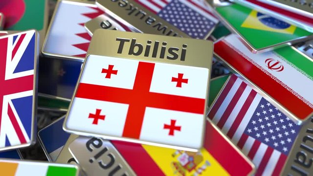 Souvenir magnet or badge with Tbilisi text and national flag among different ones. Traveling to Georgia conceptual intro animation