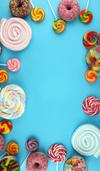 candies with jelly and sugar. colorful array of different childs sweets and treats on blue
