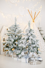 Stylish wooden Christmas fir-tree. Vintage New Year decorations. Gift boxes  under fir-tree. Christmas mood. Celebrating of New Year