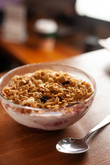 Homemade granola with yoghurt and raisins for rustic breakfast