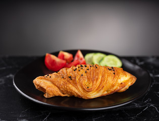 Fried pastries on a black plate on a white table.	