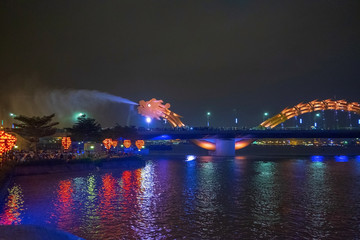 Naklejka na ściany i meble Dragon bridge in Da Nang, Vietnam, at night. The dragon blowing hot fire out of its mouth. A famous attraction in Da Nang.