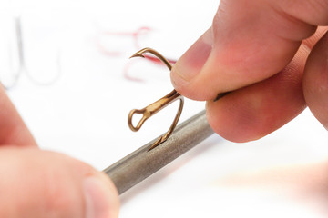 sharpening fishing hooks on a grindstone