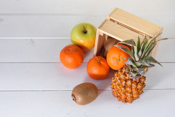 Group of fresh tropical fruits near small wooden box.
