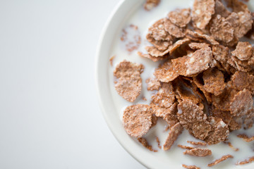 Bowl of multigrain natural flakes with milk  on a white background. Healthy food. 