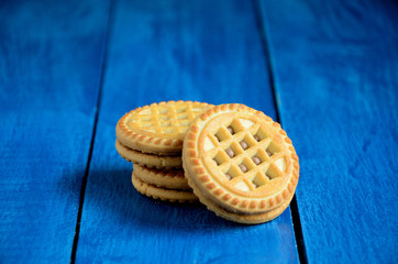 Round biscuits on a blue wooden table background.