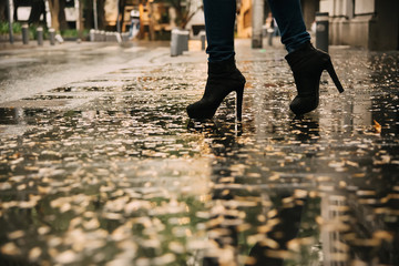 Woman walking on the sidewalk after the rain