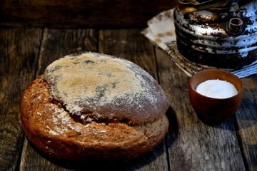 , bread, salt, aluminum old kettle, on a wooden table in the kitchen.