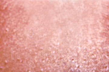 Blurred view of shiny rose gold surface as background