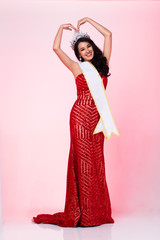 Portrait of Miss Pageant Contest in Asian Red Sequin Evening Ball Gown dress with Silver Diamond Crown Sash, fashion make up face hair style, studio lighting white background isolated copy space