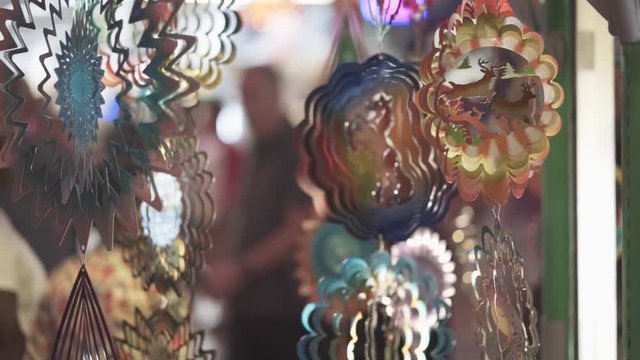 Slow motion static shot of some hand made colorful trinkets of animals, insects and objects along with a blurry background - bokeh.