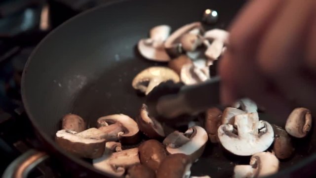 closeup slow motion sauteing cremini mushrooms
