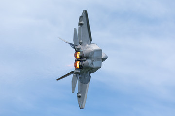 Naklejka na ściany i meble Very close tail view of a F-22 Raptor, with afterburners on 