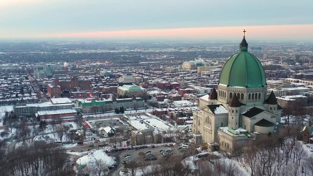 drone shot of a cross over looking a city during the twilight hours.